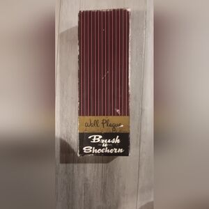 Wall plaque with brush and shoehorn